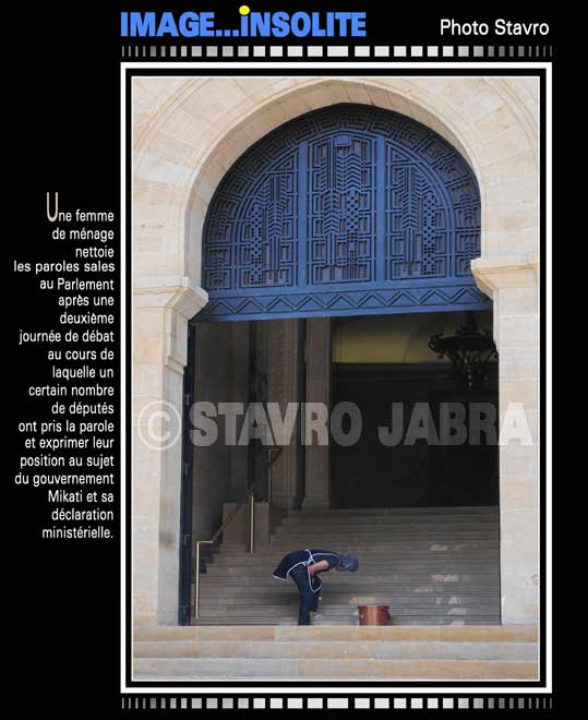 photo stavro - Une femme de mnage nettoie les paroles sales au Parlement libanais aprs une journe de dbat