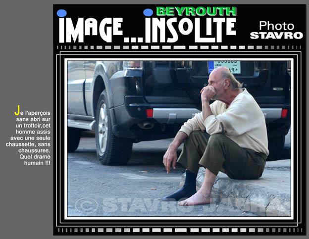 photo stavro-Je l'aperois sans abri sur un trottoir cet homme assis avec une seule chaussette, sans chaussures. Quel drame humain !!!